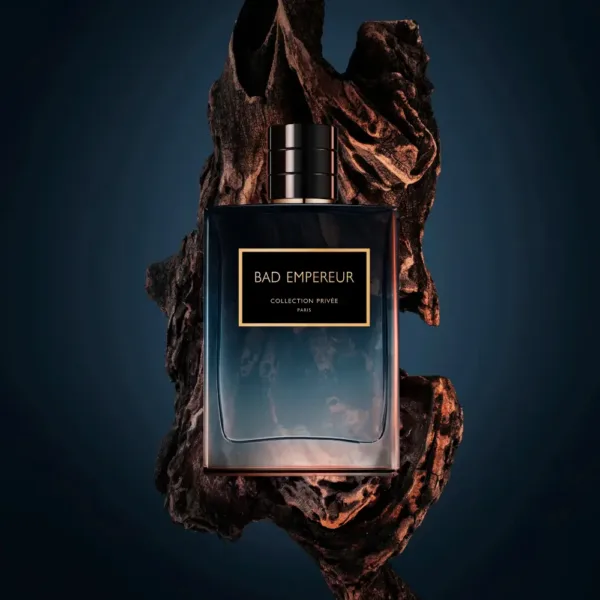 Flacon de parfum BAD EMPEREUR sur bois, fond bleu, évoquant une fusion entre nature brute et raffinement.