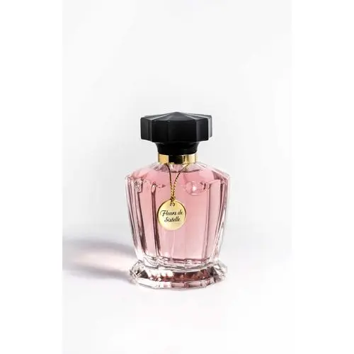 Parfum “Fleur de Sistelle” dans flacon rose transparent, capuchon noir et détails dorés.