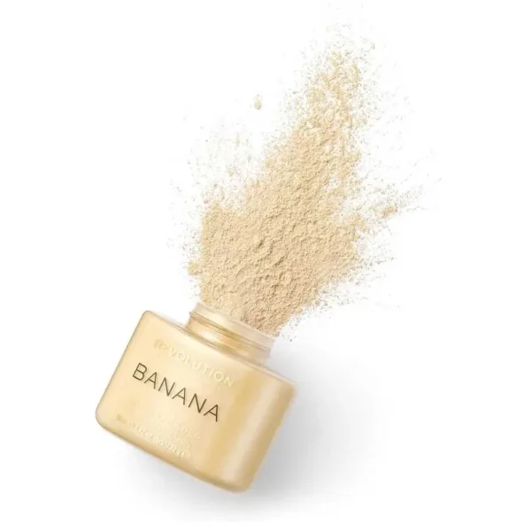 Poudre libre de maquillage "Banana" de Revolution, avec un effet de dispersion de la poudre, dans un pot doré.