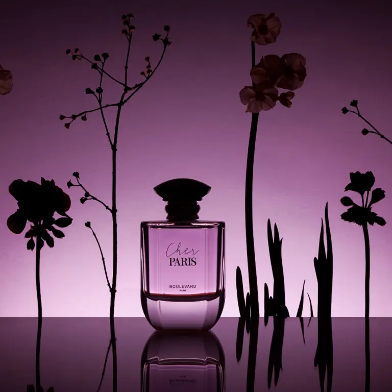 Flacon de parfum Chez Paris sur fond violet avec silhouettes florales.