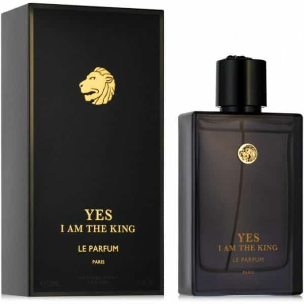 Image d’un flacon de parfum et de son emballage. Le flacon est en verre teinté noir avec un bouchon noir, et il porte une étiquette dorée avec l’inscription “YES I AM THE KING LE PARFUM”. L’emballage est une boîte noire avec un lion doré en relief sur le dessus et les mêmes inscriptions que sur le flacon.