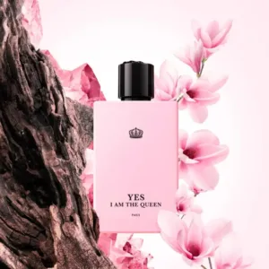 Flacon de parfum féminin rose “YES I AM THE QUEEN”, fond floral et rocheux.